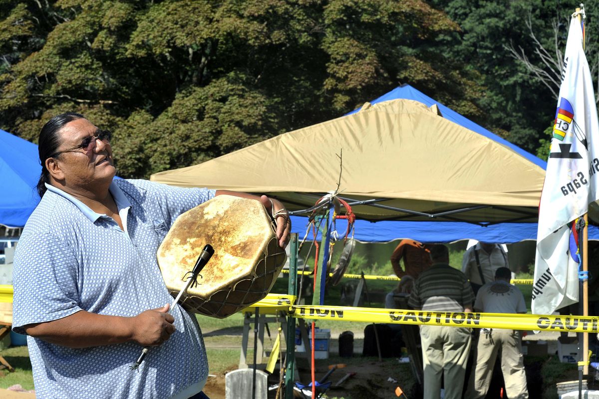 In this Aug. 16, 2012 photo, Richard Red Elk beats a drum during a ceremony near the grave of Albert Afraid of Hawk in Wooster Cemetery, in Danbury, Conn. More than a century after dying from food poisoning while touring New England with Buffalo Bill