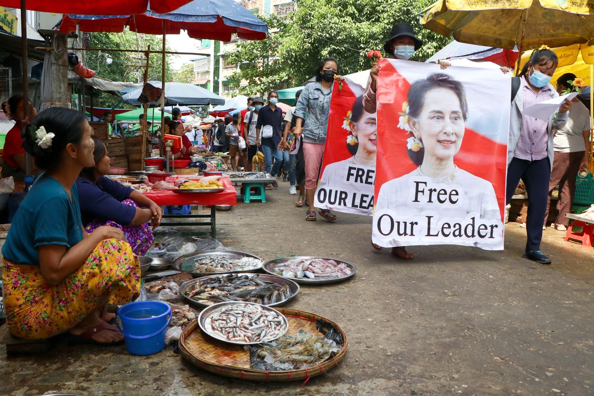 Anti-coup protesters walk through a market with images of ousted Myanmar leader Aung San Suu Kyi at Kamayut township in Yangon, Myanmar Thursday, April 8, 2021. They walked through the markets and streets of Kamayut township with slogans to show their disaffection for military coup.  (STR)