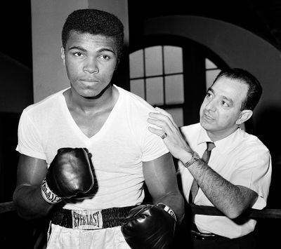 Muhammad Ali – then known as Cassius Clay – stands with trainer Angelo Dundee in this 1962 photo. (Associated Press)