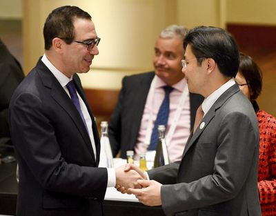 U.S. Treasury Secretary Steven Mnuchin, left, shakes hands with Lawrence Wong, Singaporean minister for national development, at the G20 finance ministers meeting in Baden-Baden, southern Germany, Friday, March 17, 2017. (Uwe Anspach / dpa)