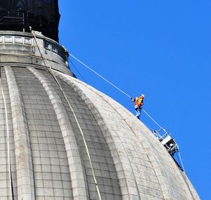 A worker from Western Waterproofing Co. of Seattle makes his way down the Capitol dome as part of a $1.1 million cleanup project for the exterior of the 84-year-old building. (Jim Camden)