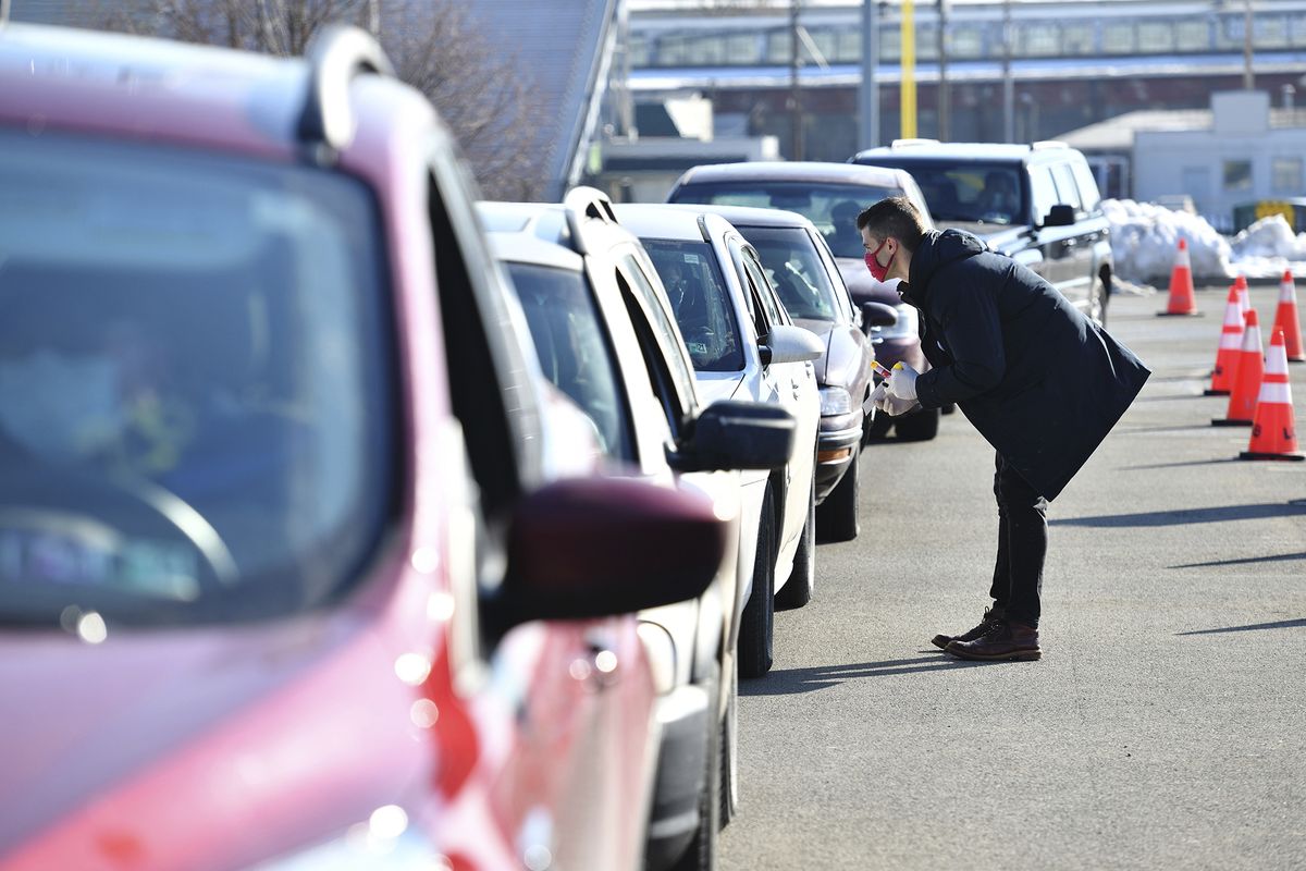 Pharmacist Mike Ruane, of Scranton, talks to patients who signed up to receive a COVID-19 vaccine during a drive-thru clinic at Scranton High School in Scranton, Pa., Friday, Feb. 26, 2021. (Sean McKeag)