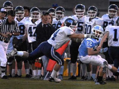 
Gonzaga Prep's Luke Sicilia gets a handful of face mask – and is penalized for it – as he pulls down Central Valley's Brad Whitley. 
 (Jed Conklin / The Spokesman-Review)