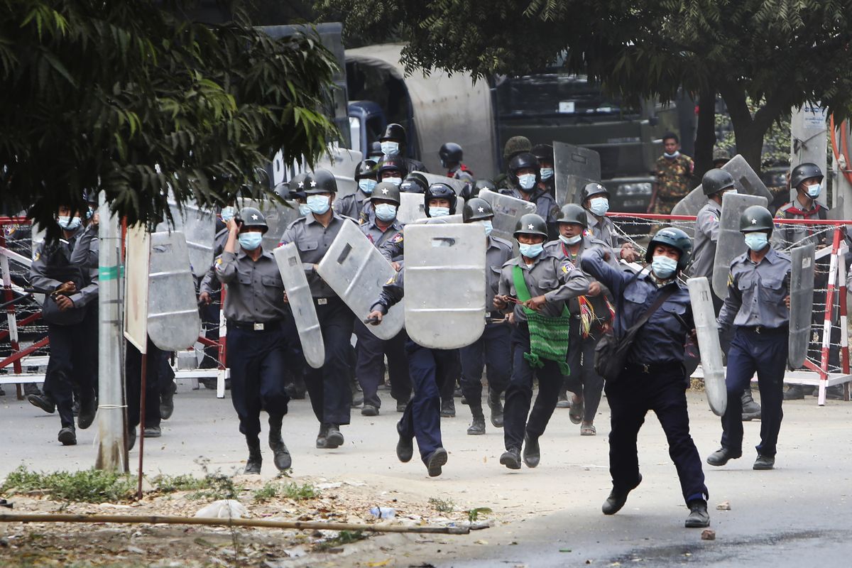 Police charge forward to disperse protesters in Mandalay, Myanmar on Saturday, Feb. 20, 2021. Security forces in Myanmar ratcheted up their pressure against anti-coup protesters Saturday, using water cannons, tear gas, slingshots and rubber bullets against demonstrators and striking dock workers in Mandalay, the nation