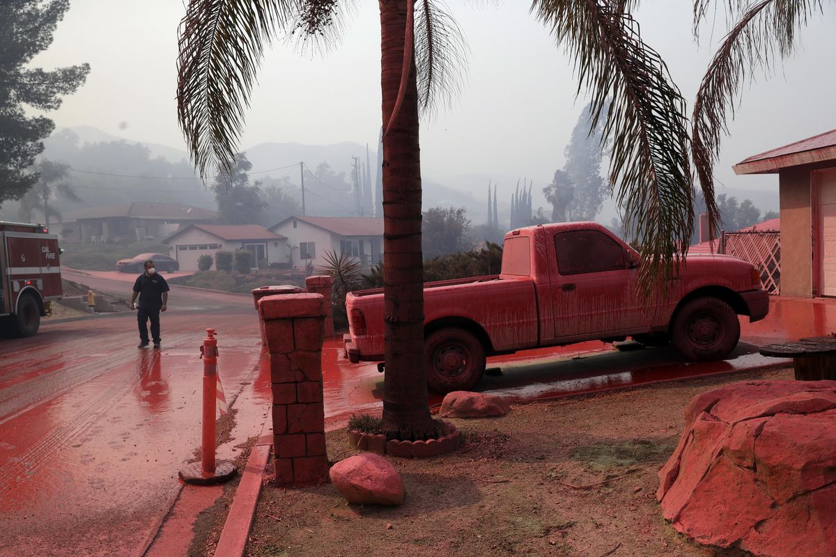 A truck and a street are covered in fire retardant dropped by an air tanker as crews battle a wildfire Friday, Aug. 10, 2018, in Lake Elsinore, Calif. (Marcio Jose Sanchez / Associated Press)