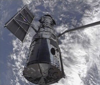 In this image from NASA TV, the Hubble Space Telescope is shown being held by the robotic arm from Shuttle Atlantis on Wednesday, setting the stage for five days of formidable repairs. (Associated Press / The Spokesman-Review)