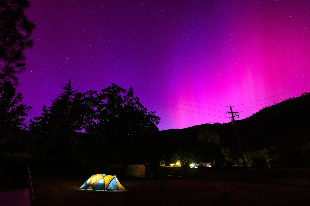 The northern lights, or aurora borealis, illuminate the night sky over a camper’s tent north of San Francisco in Middletown, Calif., on Saturday.  (Josh Edelson/AFP)