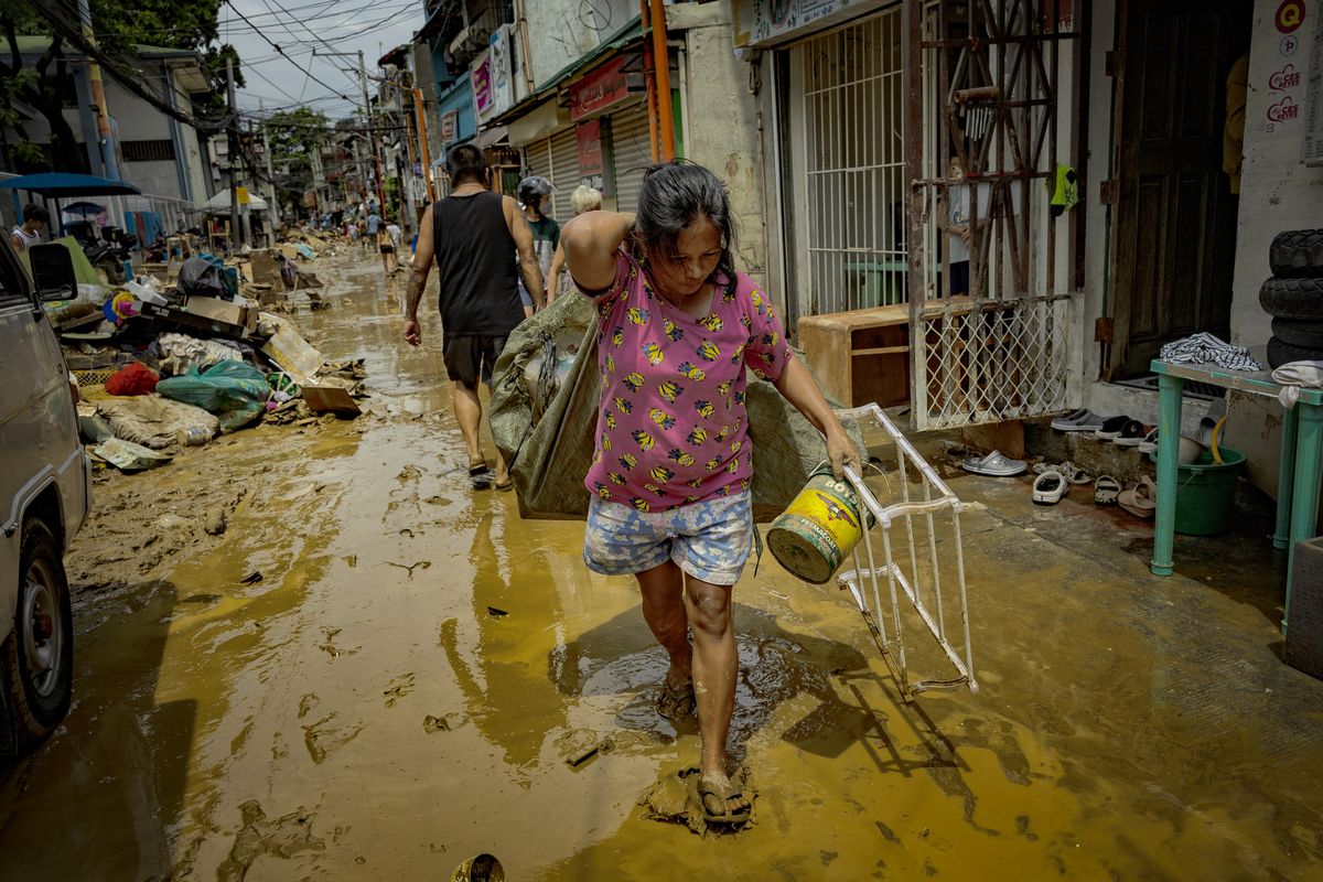 Residents clean their homes after they were flooded by Typhoon Gaemi on Thursday in Marikina, Philippines. Monsoon rains have caused flooding and landslides throughout the Philippines, resulting in at least 22 deaths and displacing over 600,000 people.  (Ezra Acayan)