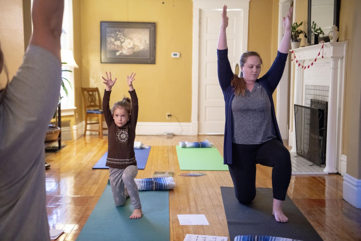 Makayla Blair, 5, performs simple yoga poses with her instructors Ainsley Peterson, right, and Taryn Bannon, seen at far left, at Yoga Calm, a program for young children who have challenges sitting still, paying attention, and staying calm. (Jesse Tinsley / The Spokesman-Review)