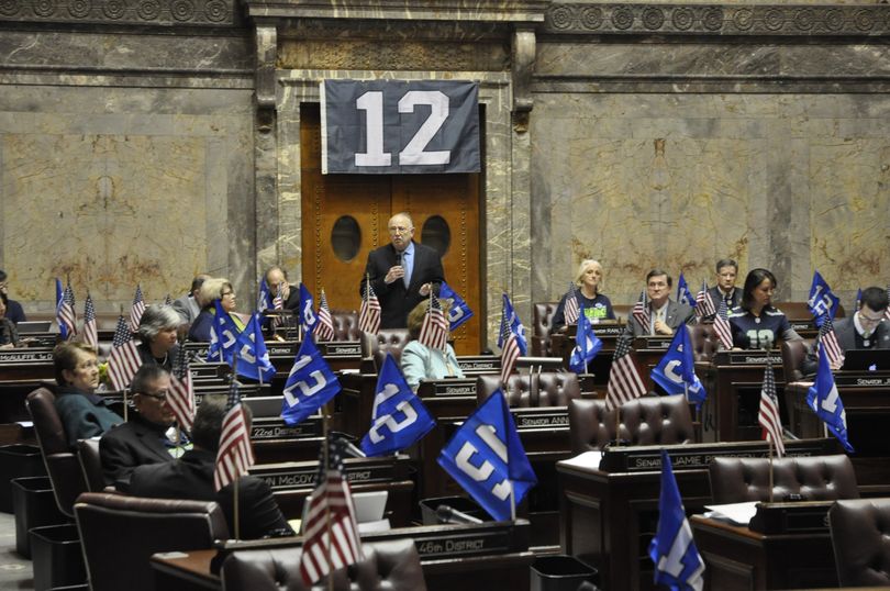 OLYMPIA -- Desks at the state Senate are decorated with both U.S flags and Seahawks' 12 flags on Friday. The Senate is scheduled to pass resolutions on the National Guard and the Seahawks. (Jim Camden)