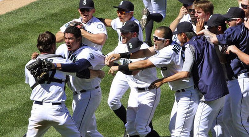 Seattle Mariners pitcher Felix Hernandez celebrates with teammates after throwing a perfect game in the Mariners' 1-0 win over the Tampa Bay Rays in a baseball game, Wednesday, Aug. 15, 2012, in Seattle. (Greg Gilbert / The Seattle Times)