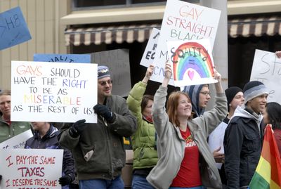 Beth Thompson, second from right,  cheers passing cars with David Chalechman, left, on Saturday in front of Spokane City Hall on Spokane Falls Boulevard. The demonstration was among dozens nationwide  protesting the approval of Proposition 8  in California.  (Jesse Tinsley / The Spokesman-Review)