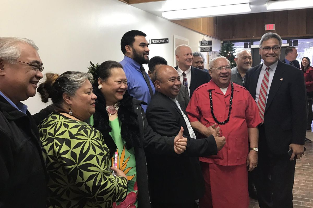 WSU’s Robert Barber, in the back, poses for photo with family and friends, including former WSU QB Jack Thompson, right, after a Colfax County judge rules in favor of the Cougar defensive player. (Jacob Thorpe / The Spokesman-Review)
