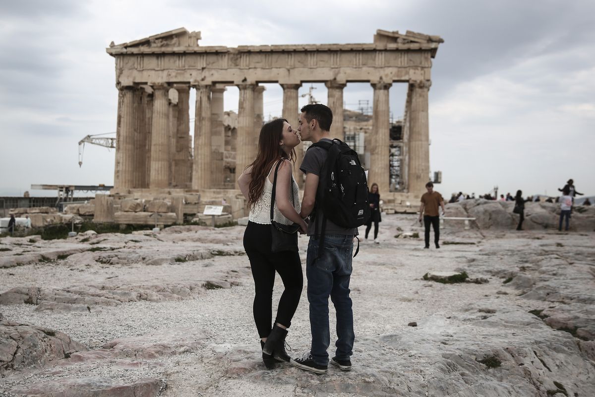 Californians Zach Branch, right, and Madison Franklin kiss in front of the Parthenon in Athens on Wednesday during their European vacation. (Associated Press)
