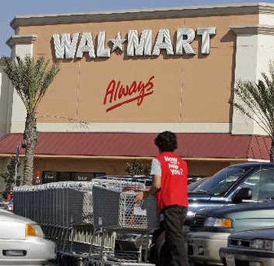 
A worker pushes carts through the parking lot toward a Wal-Mart in Norwalk, Calif. .
 (Associated Press / The Spokesman-Review)