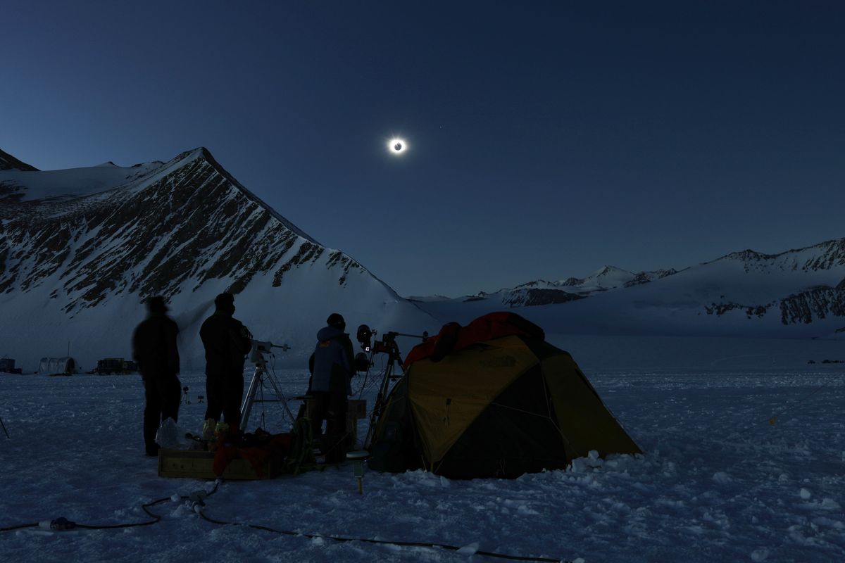 In this photo provided by Imagen de Chile, people view a total solar eclipse from Polar Union Glacier Camp in Antarctica on Dec. 4.  (Felipe Trueba/Imagen de Chile)