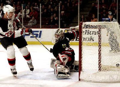 
New Jersey's Viktor Kozlov (22) scores against Chicago's Adam Munro. 
 (Associated Press / The Spokesman-Review)