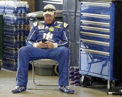 Race driver driver Dale Earnhardt Jr. looks at his phone before a practice session for the NASCAR auto race at Indianapolis Motor Speedway, in Indianapolis Saturday, July 22, 2017. (Darron Cummings / Associated Press)