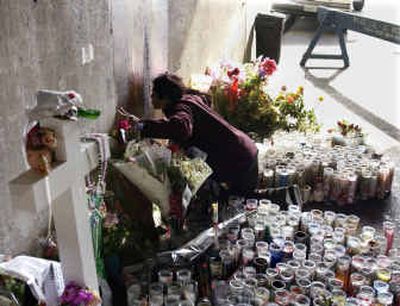 
Teresa Arias kisses a freshly painted area over a stain Friday in an underpass on a Chicago expressway that some believed was an image of the Virgin Mary. 
 (Associated Press / The Spokesman-Review)