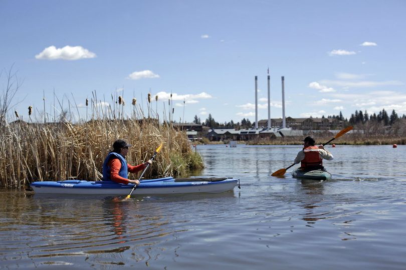 Sasha Sulia, left, and Jason Scarberry, of the Bend Park & Recreation District, look for nesting geese on an island in the Deschutes River up from the Colorado Avenue bridge April 18, 2013. Since mid-March, the park district has focused on finding goose nests and smearing corn oil on the eggs to prevent them from hatching. (Associated Press)