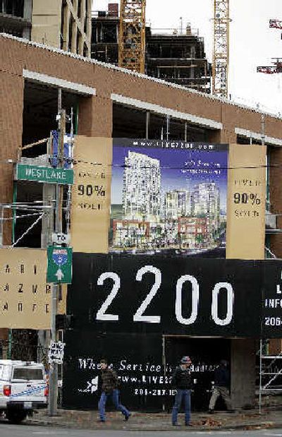 Pedestrians walk past a sign saying that 90 percent of the units in a new 261-condominium project in downtown Seattle have been already sold, on Tuesday. Sales of new homes jumped to an all-time high in October in what could be a final spurt from a housing market that is expected to slow after five record-breaking years.
(Associated Press / The Spokesman-Review)