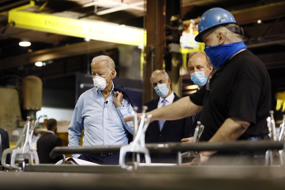 FILE - In this July 9, 2020, file photo Democratic presidential candidate, former Vice President Joe Biden, from left, Sen. Bob Casey, D-Pa., and McGregor Industries owner Bob McGregor listen to First Class Fitter Michael Phillips during a tour of the metal fabricating facility in Dunmore, Pa. Biden is pledging to define his presidency by a sweeping economic agenda beyond anything Americans have seen since the Great Depression and the industrial mobilization for World War II.  (Matt Slocum)