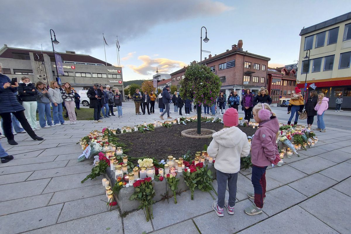 People gather around flowers and candles after a man killed several people on Wednesday afternoon, in Kongsberg, Norway, Thursday, Oct. 14, 2021. The bow-and-arrow rampage by a man who killed five people in a small town near Norway