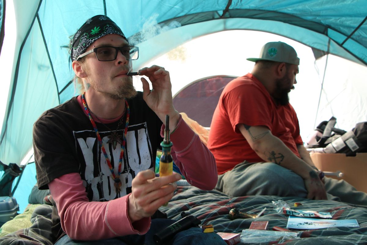 Dax Taylor, a Pullman resident and one of the Weedstock organizers, smokes in a tent with friends. (Cody Alan Cottier / For The Spokesman-Review)