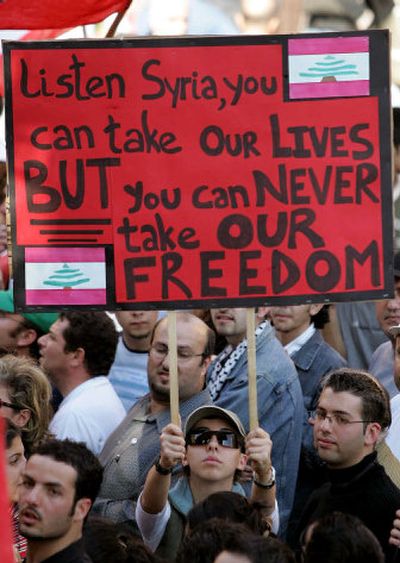 
A Lebanese protester holds a placard during Wednesday's funeral procession of slain anti-Syrian journalist and legislator Gibran Tueni and his two bodyguards in Beirut, Lebanon.
 (Associated Press / The Spokesman-Review)