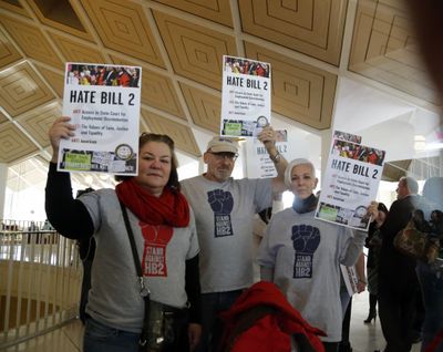 Opponents of House Bill 2 hold signs outside the House chambers gallery as the North Carolina General Assembly convenes for a special session at the Legislative Building in Raleigh, N.C., Wednesday, Dec. 21, 2016. North Carolina’s Republican legislature  has failed to repeal a 9-month-old law that limited LGBT rights, including where transgender people can use bathrooms in schools and government buildings. (Chris Seward / Associated Press)