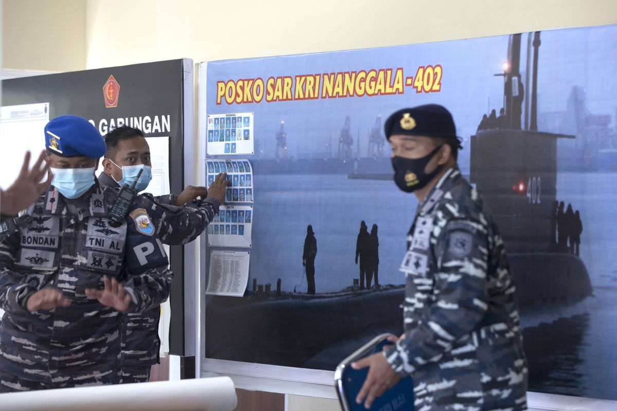 A member of Indonesian military officials sets the pictures of Indonesian Navy submarine KRI Nanggala that went missing while participating in a training exercise on Wednesday, at a command at Ngurah Rai Airport, Bali, Indonesia on Friday, April 23, 2021. Rescuers continued an urgent search Friday for an Indonesian submarine that disappeared two days ago and has less than a day's supply of oxygen left for its crew.  (Firdia Lisnawati/Associated Press)