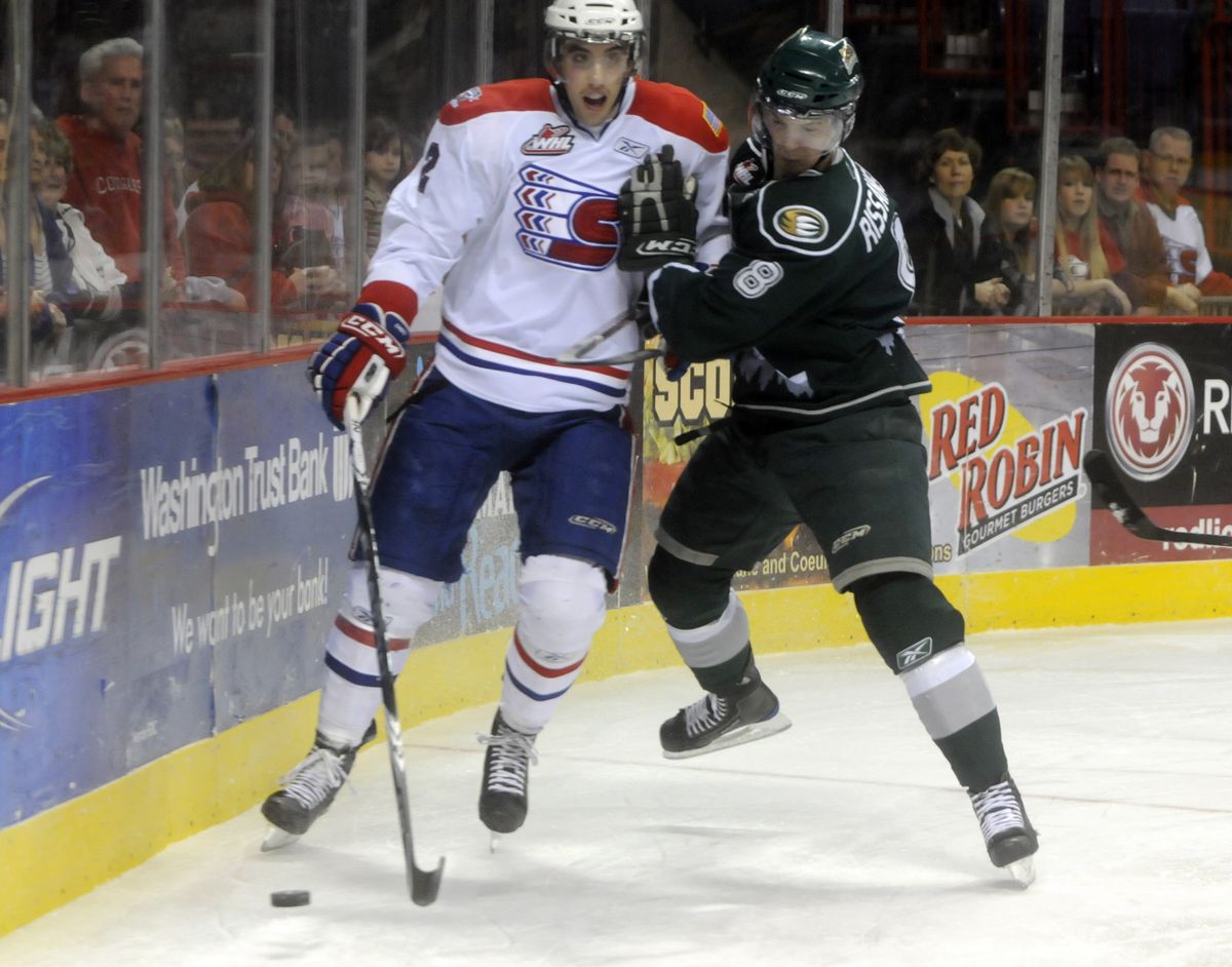 bartr@spokesman.com Chiefs defenseman Jared Cowen prepares himself for a hit by Everett defenseman Rasmus Rissanen in the first period. (J. BART RAYNIAK)