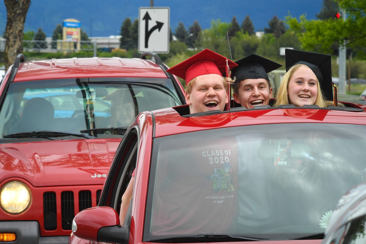Ferris High School senior Will Clements, along with Lewis and Clark High school seniors, Caleb Bopp and Karrigen Hanson wait in line for a free Krispy Kreme Graduation Dozen donuts each, Tuesday, May 19, 2020, in Spokane Valley. On Wednesday, the Spokane School Board was brief on how high school graduates will receive their diplomas. Officials have decided to hold modified drive-thru observances at each high school. (Dan Pelle / The Spokesman-Review)