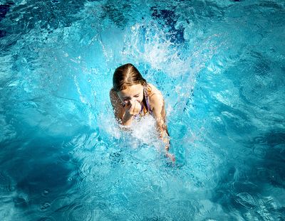 Coral Deitch, 8, cannonballs into Comstock pool in this photo from 2021. County and city pools open on Monday this year.  (COLIN MULVANY/THE SPOKESMAN-REVIEW)