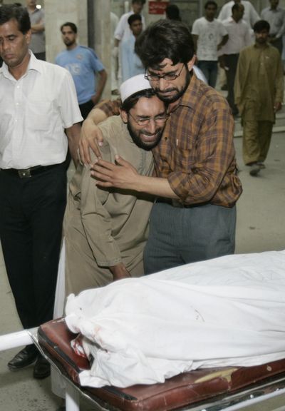 Family members grieve over the body of an explosion victim Saturday at a hospital in Islamabad.  (Associated Press / The Spokesman-Review)