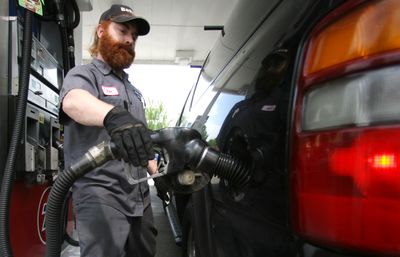 A gasoline attendant pumps gas Wednesday in Portland. Oil prices hit a six-month high Wednesday, climbing above $62 a barrel.  (Associated Press / The Spokesman-Review)