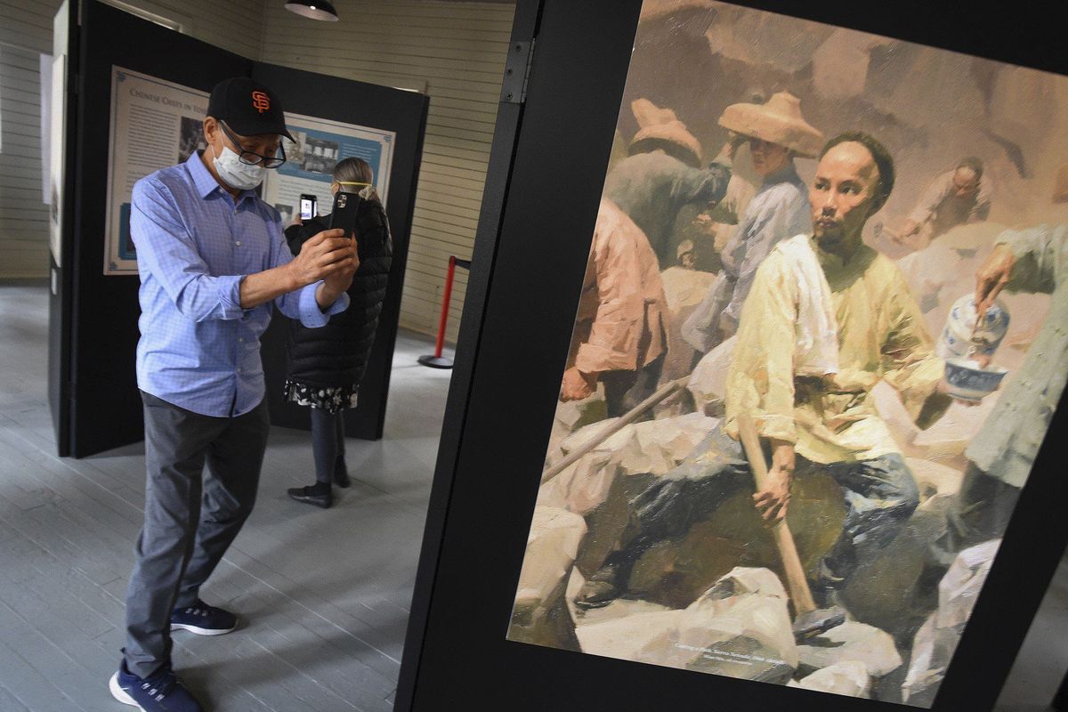 Ed Hung of San Francisco takes a photo of a Chinese laborer in an exhibit in the restored 1917 Chinese laundry building, after its dedication Friday in Yosemite National Park, Calif.  (MBI)