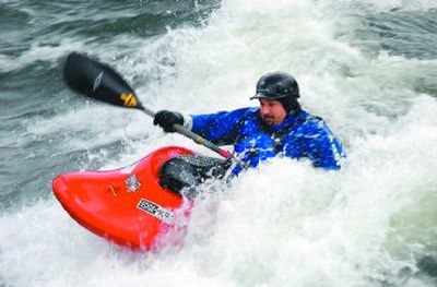 
Post Falls' Chris Hoffer surfs a wave in the Spokane River at Corbin Park in Post Falls last Saturday during the  Corbin Kickoff kayaking event. 
 (Jesse Tinsley / The Spokesman-Review)