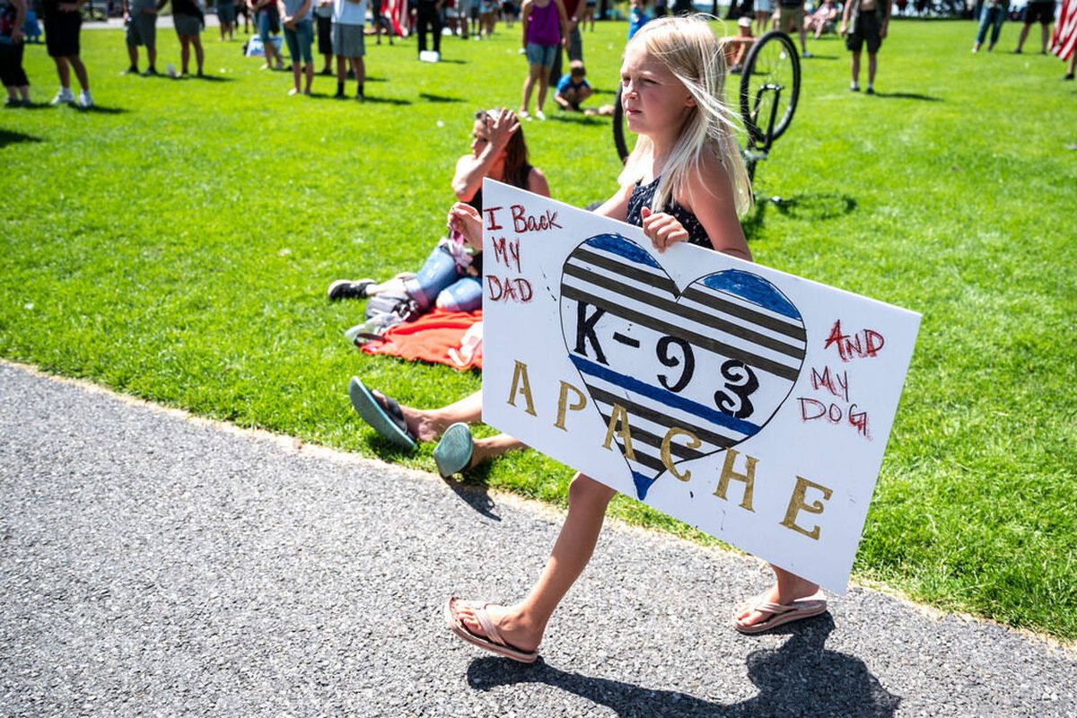 Ali Pfeifer, walks with a sign in support of her father Phil Pfeifer, a Spokane County Sheriff K-9 deputy, during a Law Enforcement Support Rally sponsored by Family of Faith Community Church on Saturday in Riverfront Park.  (Colin Mulvany/THE SPOKESMAN-REVIEW)