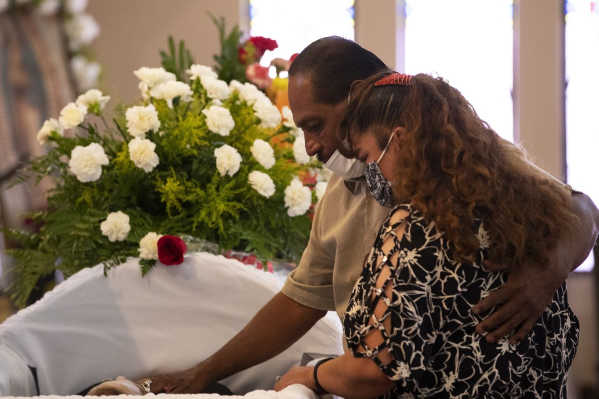 Jose Luis Ozuna and his wife, Leticia Bernal, pays respect to their friend Antonio Basco during his funeral Friday in El Paso, Texas.  (Andres Leighton)