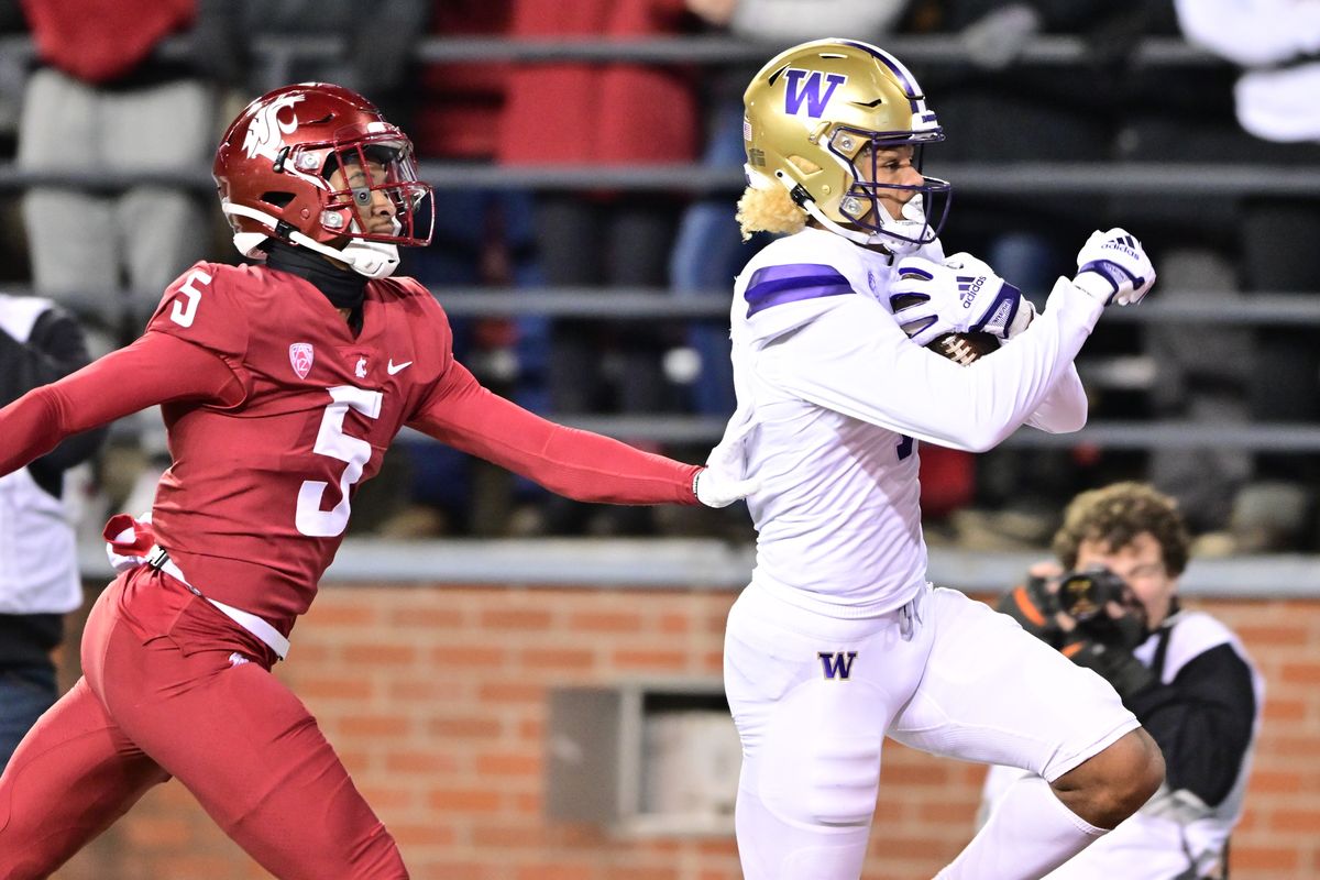 Washington Huskies wide receiver Rome Odunze, right, hauls in a long pass and runs it in for a touchdown against Washington State Cougars cornerback Derrick Langford Jr. during the first half of the Apple Cup on Saturday at Gesa Field in Pullman.  (Tyler Tjomsland/The Spokesman-Review)