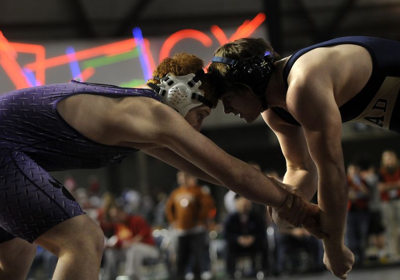 Mead's Jacob Trotter, right, goes head-to-head with Heritage's Dean Rogers in a quarterfinal match in the 4A 215 pound division. (Ingrid Barrentine / The Spokesman-Review)