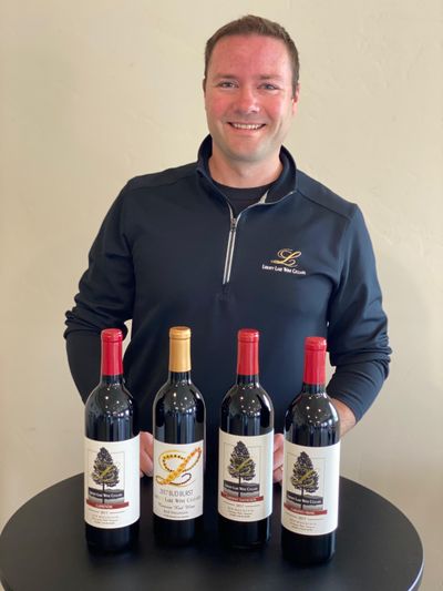 Winemaker Mark Lathrop of Liberty Lake Wine Cellars stands with four of his award-winning wines. (Courtesy)
