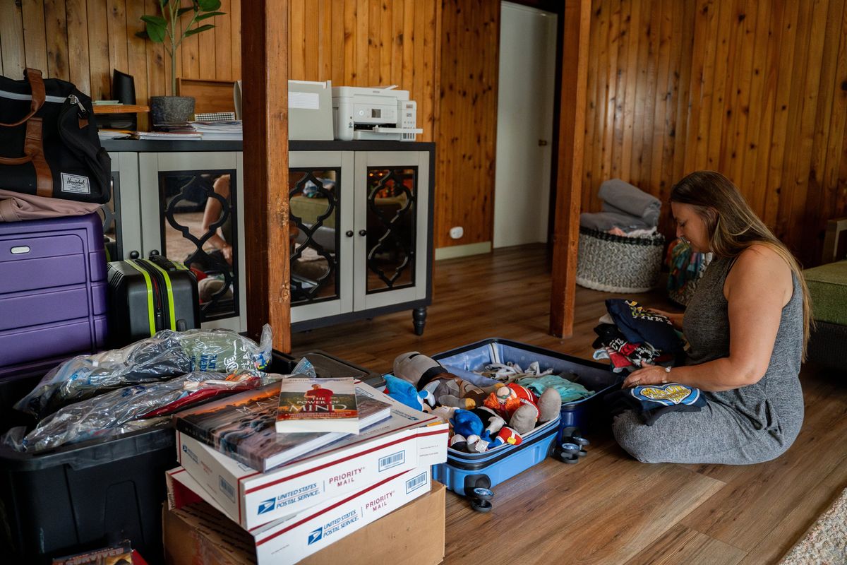 Amy Chadwick packs her son’s T-shirts and toys at her temporary home in Lahaina. Chadwick and her family of five with three dogs are moving to Florida at the end of December after losing their home in August’s wildfire. (Mengshin Lin/For The Washington Post)