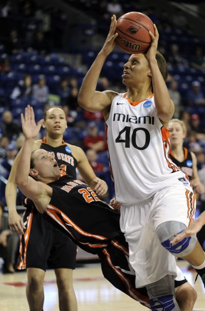 Idaho State's Ashleigh Vella (22) falls as Miami's Shawnice Wilson (40) drives to the basket in the second half of their NCAA tournament first-round woman's game Saturday at the McCarthey Athletic Center in Spokane. (Colin Mulvany)