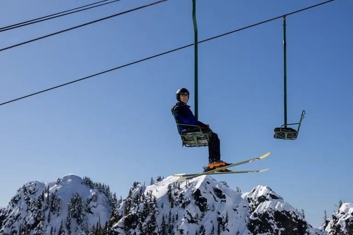 A skier marvels at the view as he nears the top of Chair 2 on Feb. 23 at the Summit at Snoqualmie’s Alpental ski area near Snoqualmie Pass. With good visibility, Glacier Peak, as well as Mounts Adams, Rainier and Baker can all be seen from the top of the chair. This winter is the last for loveseat-sized Chair 2.  (Jennifer Buchanan/The Seattle Times)