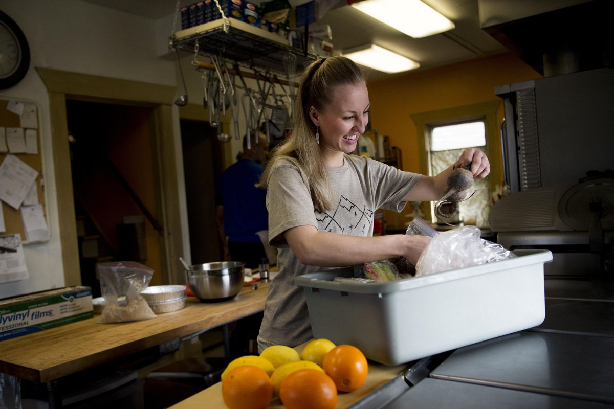 Jennifer Van Cott, owner of Pantry Fuel, a home delivery food service that offers healthy dishes, sorts through fresh ingredients while working at Gardens at Sunset