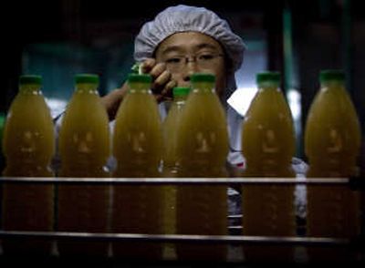 
A worker inspects juice bottles  Tuesday in Beijing, where the U.S. and China signed two trade deals. Associated Press
 (Associated Press / The Spokesman-Review)
