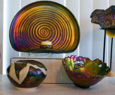 
Examples of Kosai pottery line the walls of the studio of Spokane Valley artist Lezlie Finet. She uses multiple glazes and firings to obtain the swirling vivid colors that, unlike other raku forms, will not lose their luster. Below, Finet with an example of her pottery. 
 (CHRISTOPHER ANDERSON / The Spokesman-Review)
