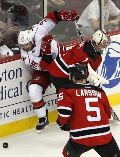 Carolina's Patrick Dwyer is stopped in his tracks by New Jersey goalie Johan Hedberg during first period of NHL game Monday. (Associated Press)